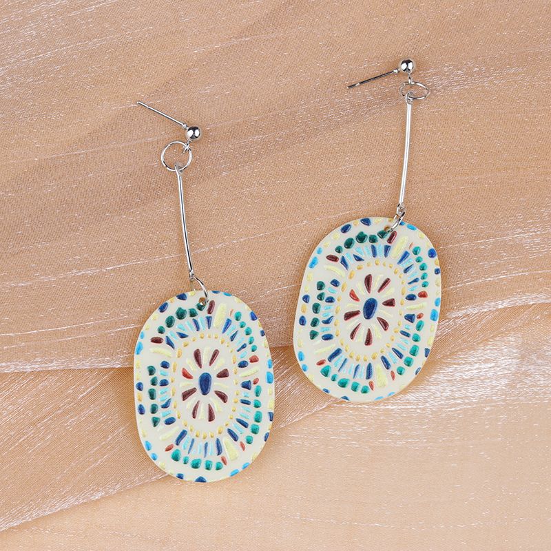 Close-up of Love Festival Earrings and Brooch on textured surface