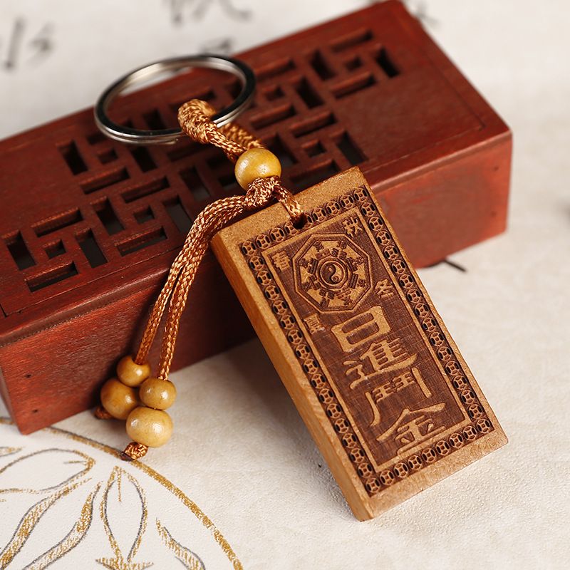 A peach wood engraved flat keychain that brings in a fortune every day