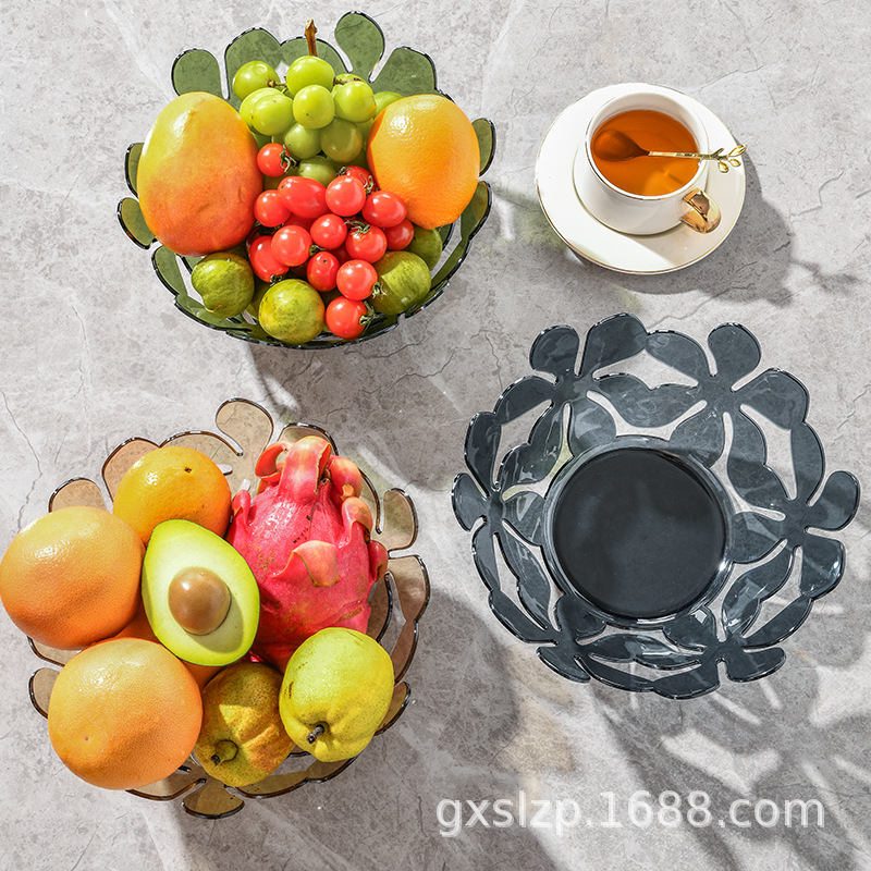 A transparent fruit plate in the living room with creative petal-shaped plastic plates and geometric storage boxes for dried fruits, candies and cookies