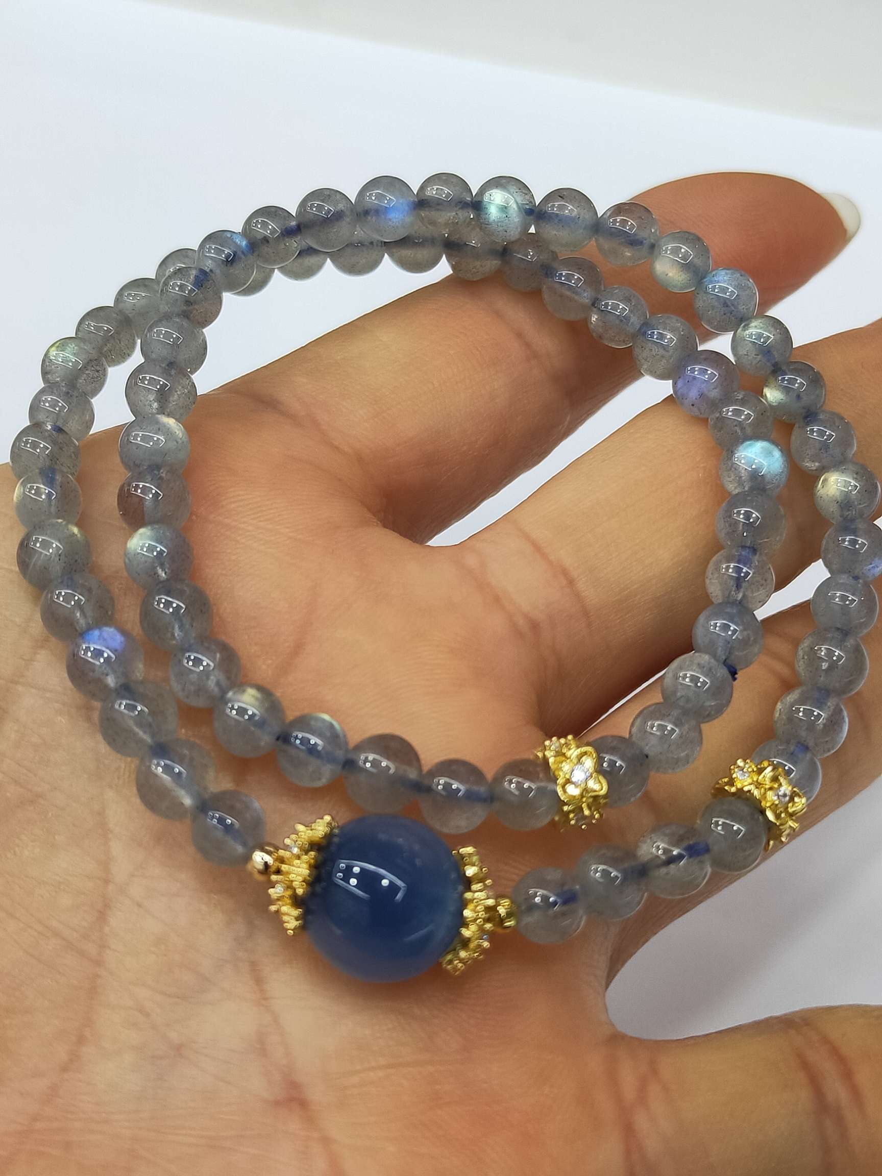 新款[玫瑰][玫瑰][玫瑰]
灰月光手链，珠子直径4毫米双圈⭕ 配珠蓝糖心10毫米，铜包真金锆石花托，桂花锆石珠。
​1