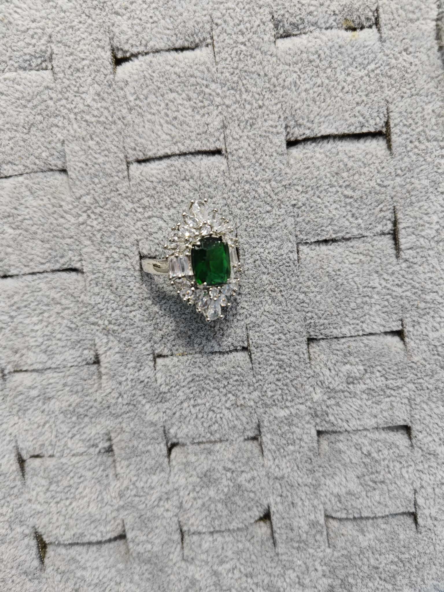 A trendy high-end women's ring made of colored gemstones and emeralds