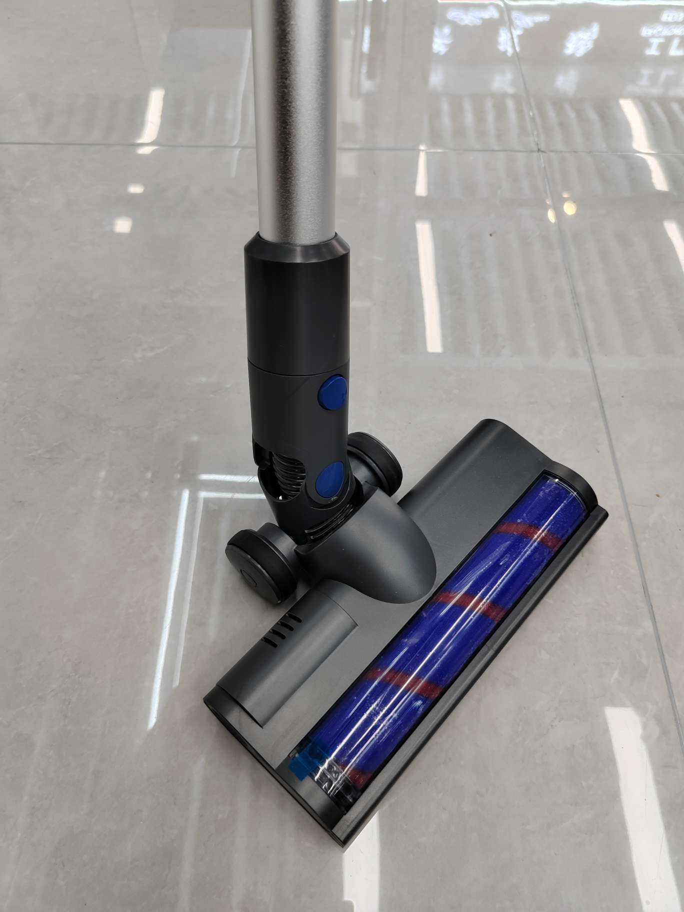 Vacuum cleaner in use on carpet with LED light illuminating debris