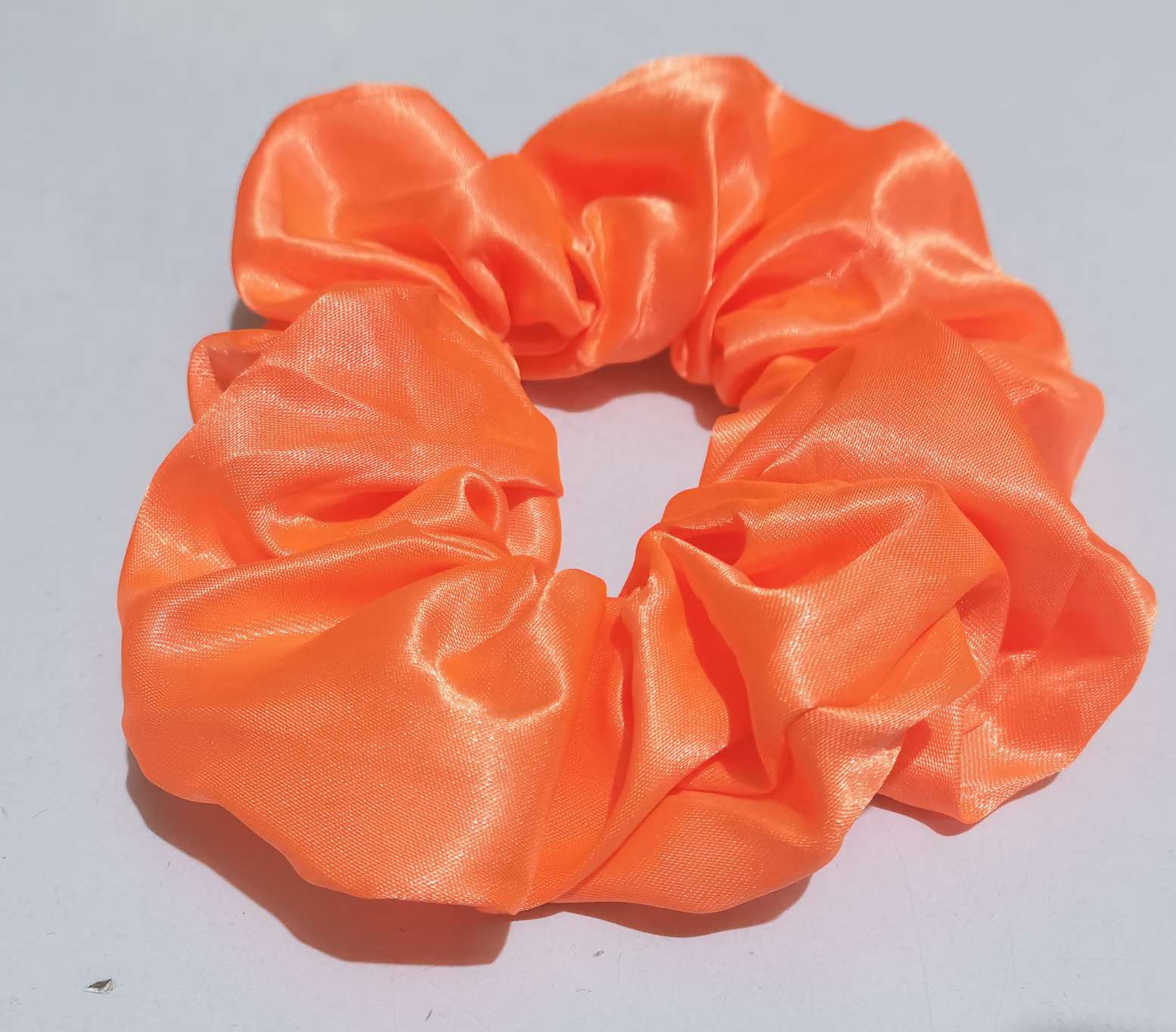 An orange-red large intestine hair band made of satin