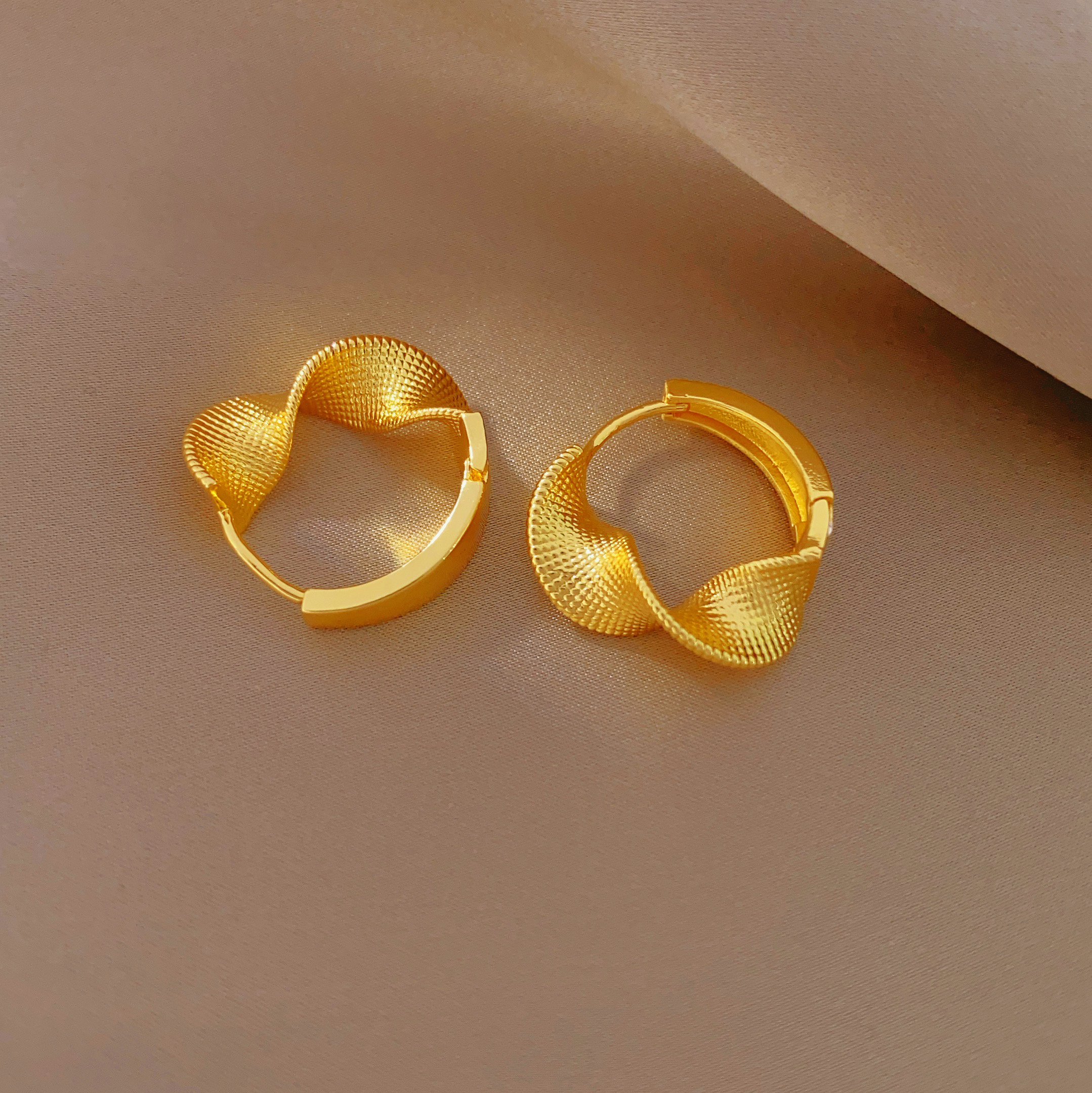 The new fashionable twisted earrings feature a niche design and a high-end feel. They are a light luxury bestseller with brushed ear loops for women