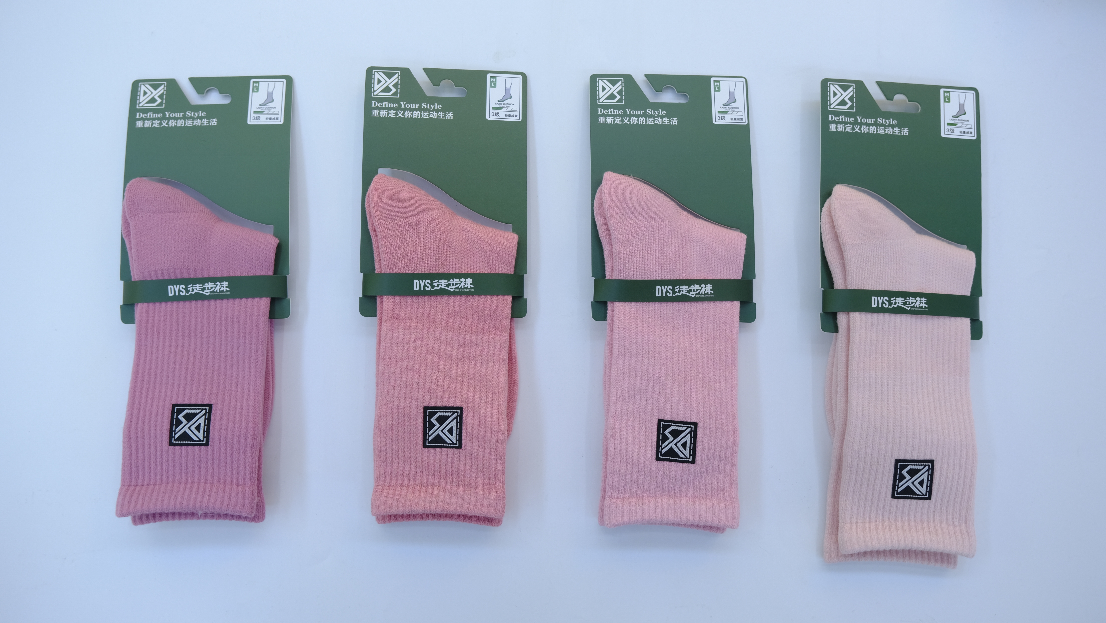 Hiker adjusting backpack with colorful socks visible above boots near pine trees