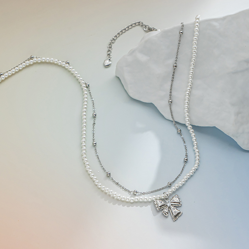 A bow pendant with pearls stacked on top of each other is an elegant and high-end pearl beaded necklace details Picture