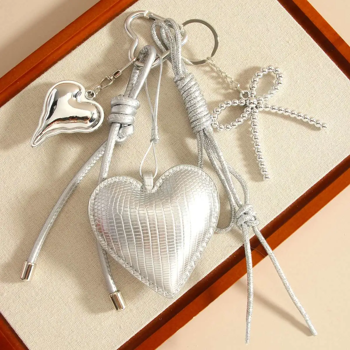 miu series original high-end silver pu heart-shaped bow woven rope bag pendant, keychain all-purpose pendant detail image 3