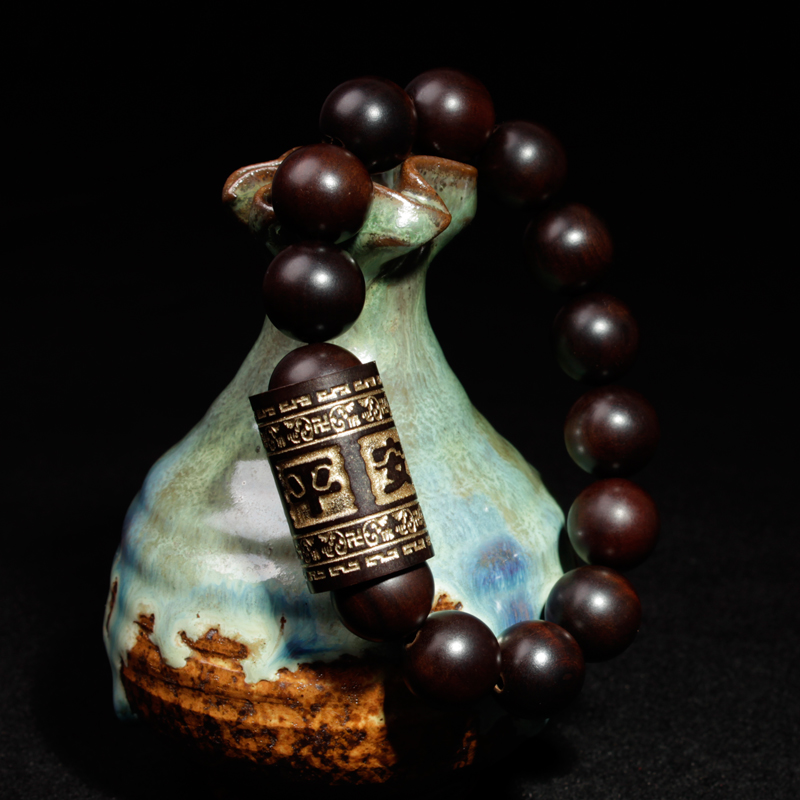 A light-struck jujube wood round bead is engraved through a gold barrel on a 13mm safe men's bracelet