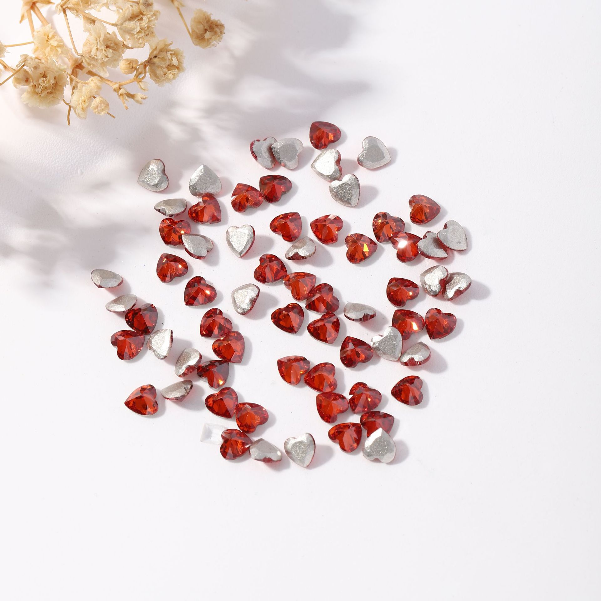 This is a popular style of teardrop-shaped pointed-bottom, irregular-shaped diamond, heart-shaped diamond, and light red nail art accessory Item Picture