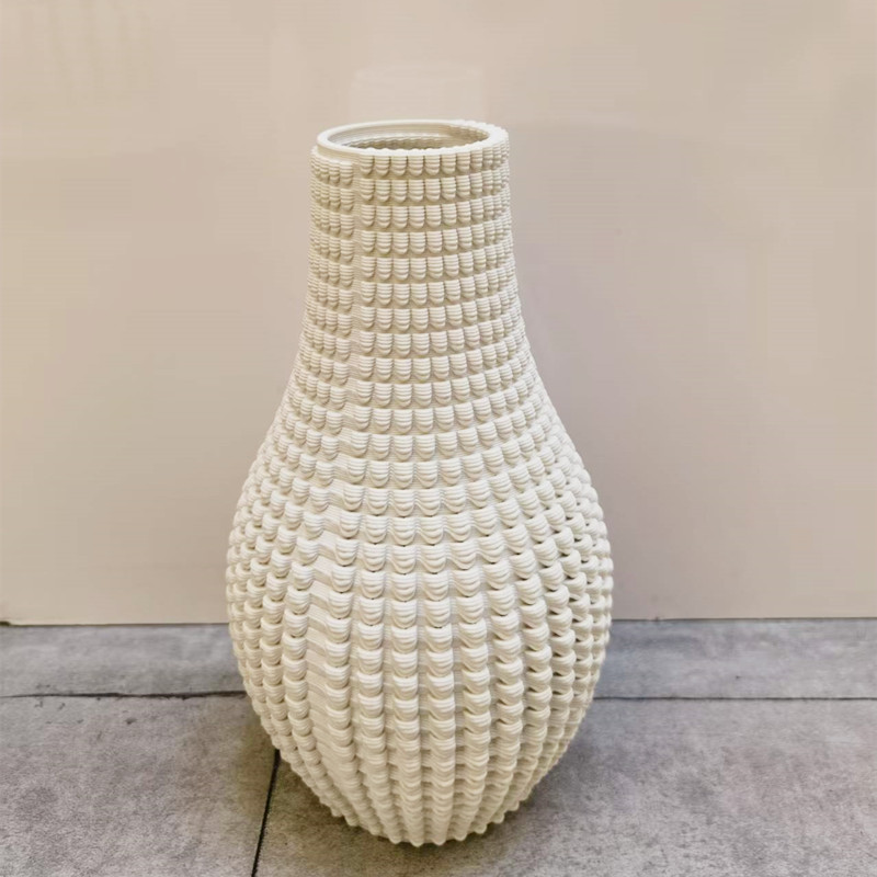 A light luxury white ceramic vase with an artistic 3D hollowed-out flower arrangement for the hotel entrance table
