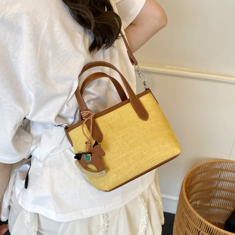 A simple and stylish hand-held bucket bag for women in the summer of 2025 with a Korean color scheme. It is a single-shoulder crossbody bag details Picture