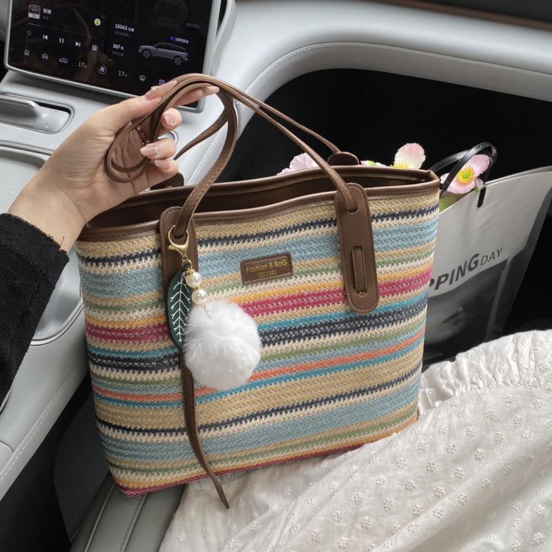 This is a new 2025 summer beach-style women's bag with a simple and versatile hand-held design. It's a single-shoulder vacation woven bag full figure