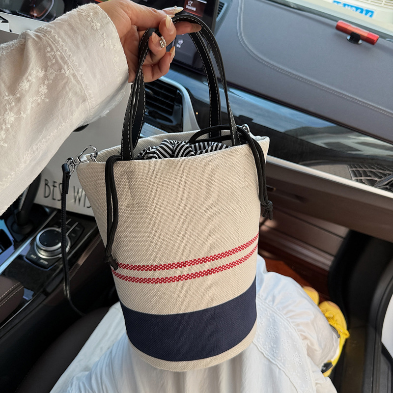 A niche design with contrasting color stripes hand-held bucket bag for women in the summer of 2025, a versatile canvas single-shoulder crossbody bag full figure
