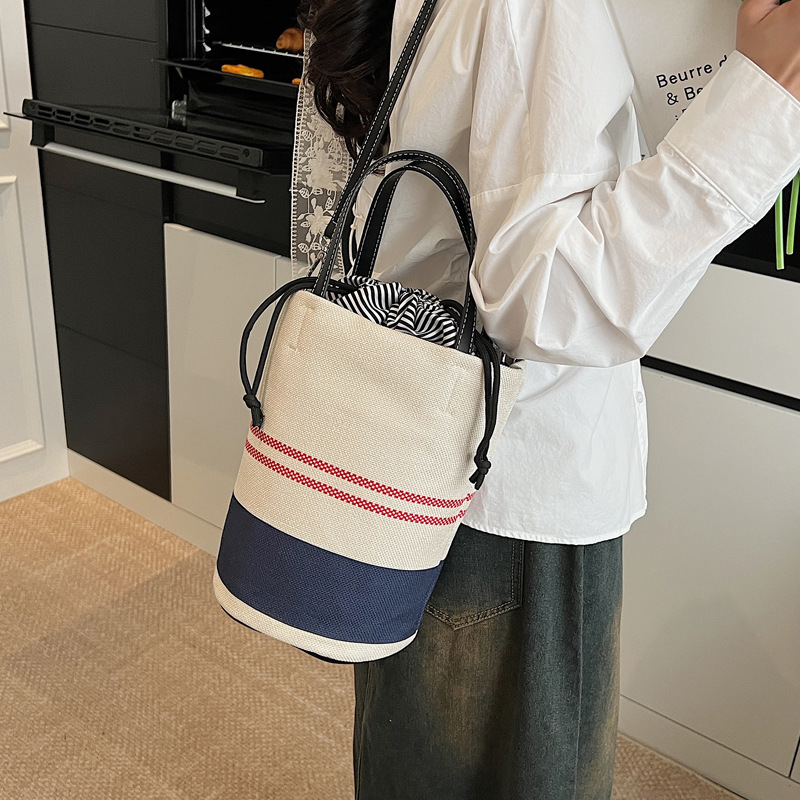A niche design with contrasting color stripes hand-held bucket bag for women in the summer of 2025, a versatile canvas single-shoulder crossbody bag details Picture