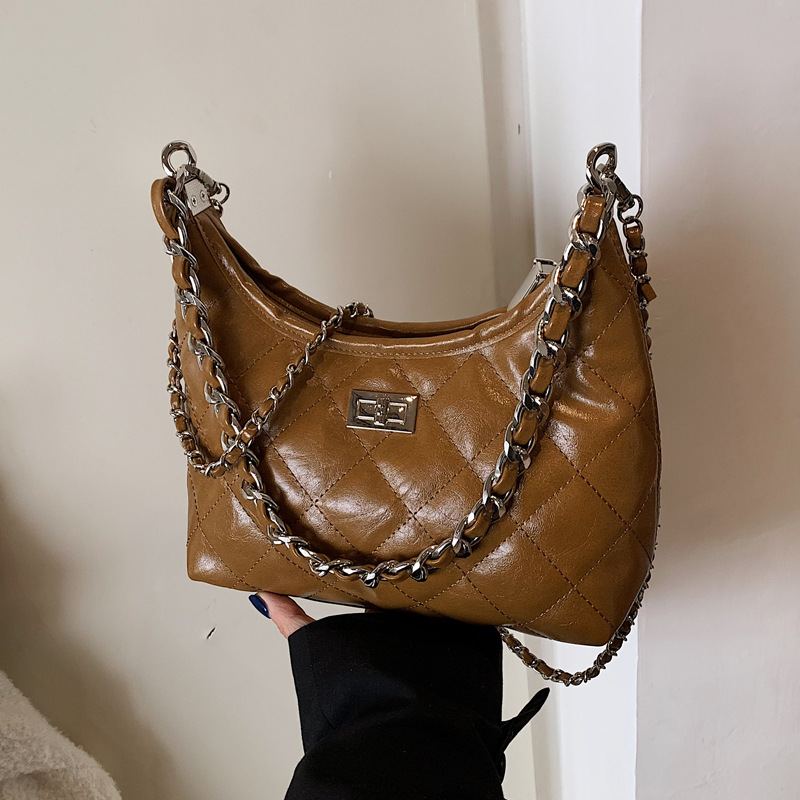 A simple and trendy crossbody bag for women in the spring of 2025 with diamond-patterned embroidery. It is a single-shoulder, underarm bucket bag details Picture