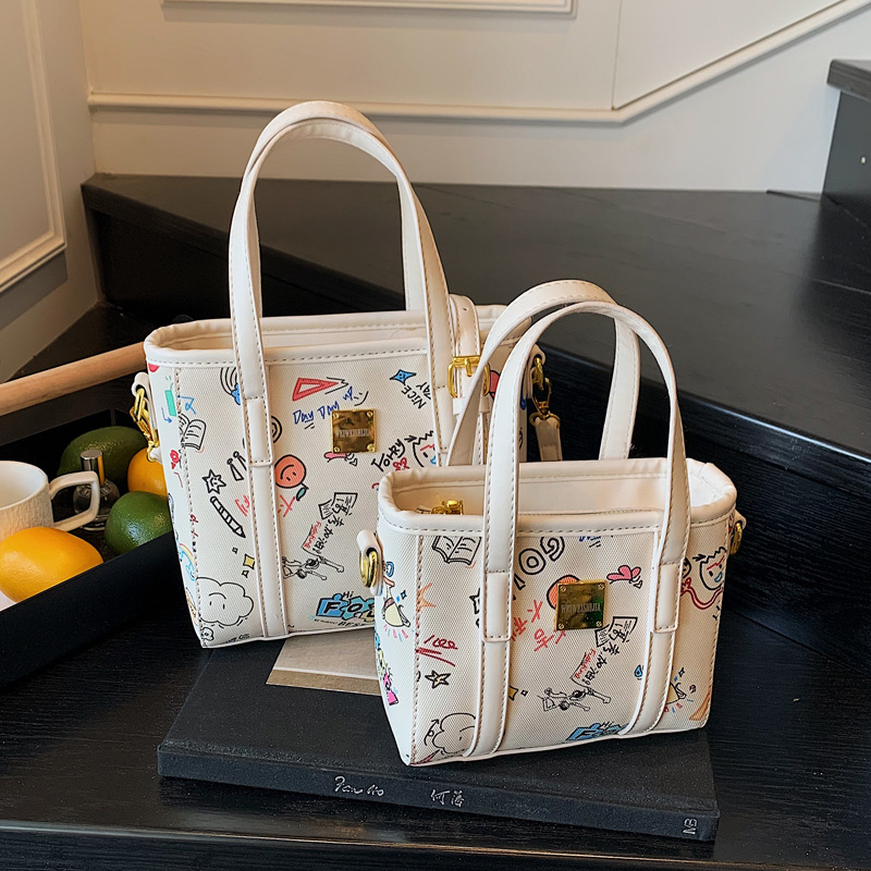 Fashionable and niche design single-shoulder crossbody bag for women 2025 new cartoon printed hand-held bucket bag with pendant full figure