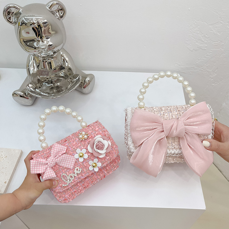 2025 New Korean version woolen, cotton and linen girls' and children's bow pearl hand-held accessory handbag full figure