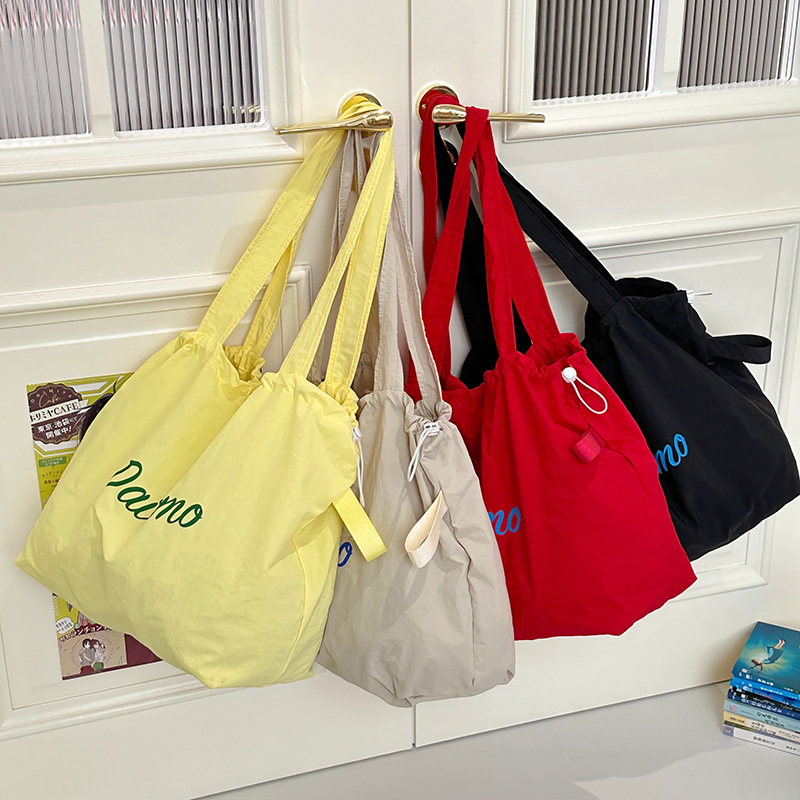 Solid color large-capacity tote bag 2025 bestseller, fashionable commuting lightweight handbag, laid-back style drawstring nylon bag for women full figure