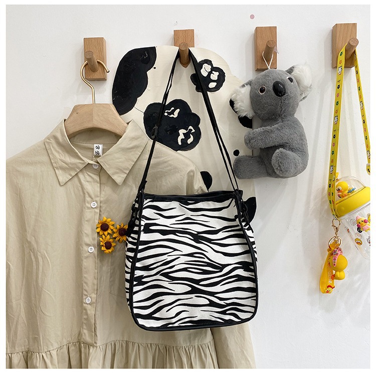 A cute hand-held canvas bag, a new trendy lady's cow pattern Japanese-style small square bag, a Haraju-style striped single-shoulder crossbody bag details Picture