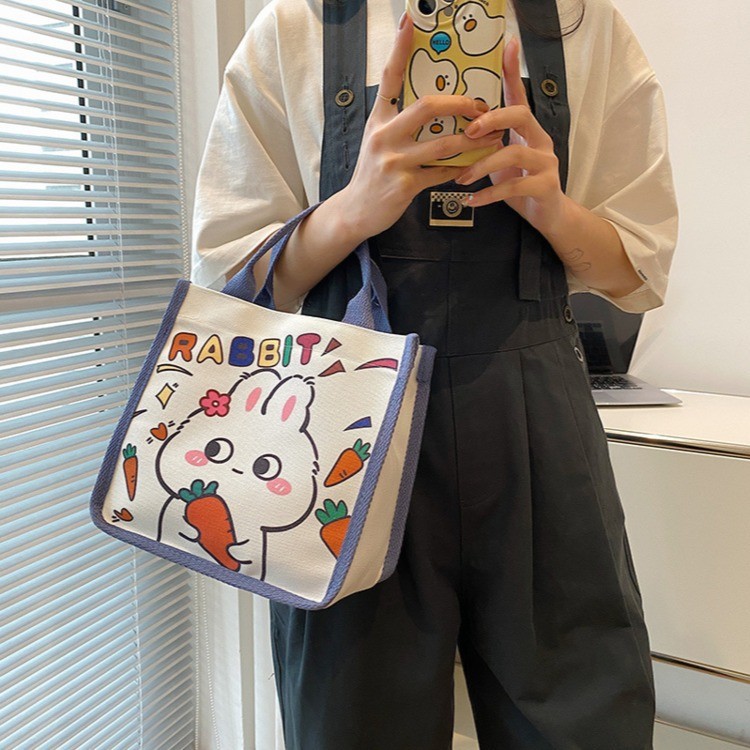 Wholesale of new Japanese-style cute canvas bags with little rabbit prints, cartoon girl tutorial bags, and portable bento bags for going out details Picture
