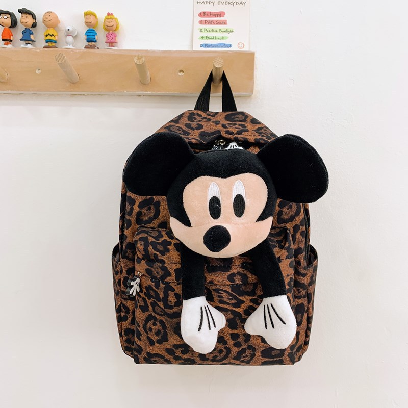 The 2025 new leopard-print backpack is a fashionable female figurine backpack with a large capacity and cute dolls. It is a best-selling student schoolbag full figure