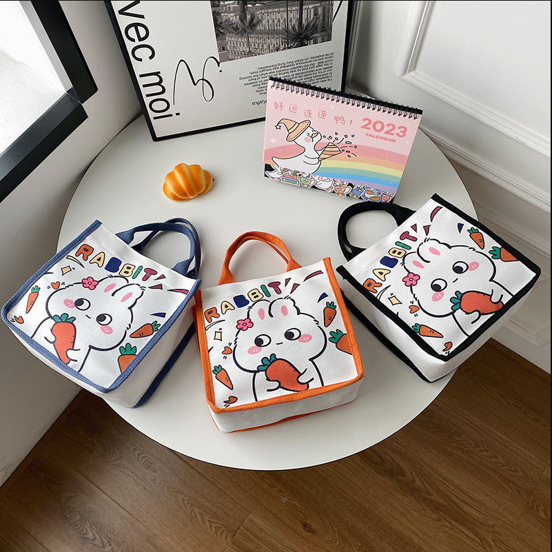 Wholesale of new Japanese-style cute canvas bags with little rabbit prints, cartoon girl tutorial bags, and portable bento bags for going out full figure