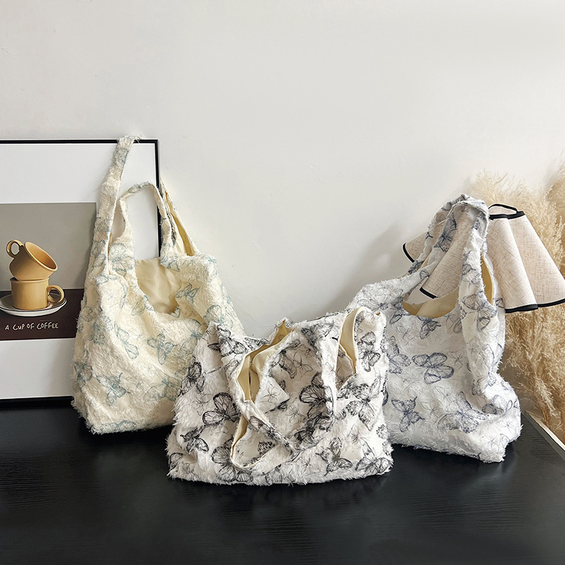 The new large-capacity floral patterned and stylish tote bag with a laid-back style and butterfly print is a casual and fresh hand-held bag full figure