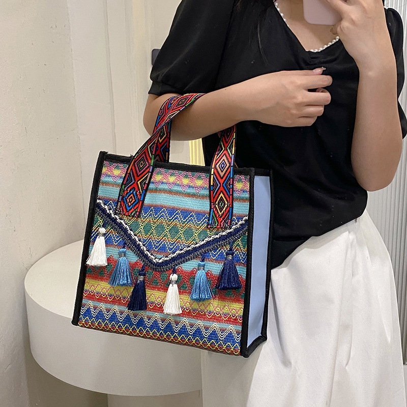 New hand-held fringed shopping bag 2022, fashionable ethnic style, Hong Kong style bucket bag, versatile woven bag for women full figure