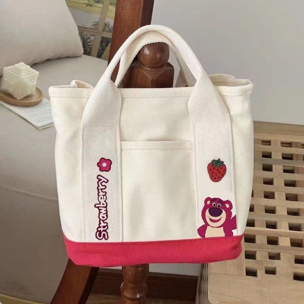 A small handbag is carried by a female student going out. She is carrying a 2024 new style bag, a mini canvas bag, and a Korean version bento bag for female students Application Scenario