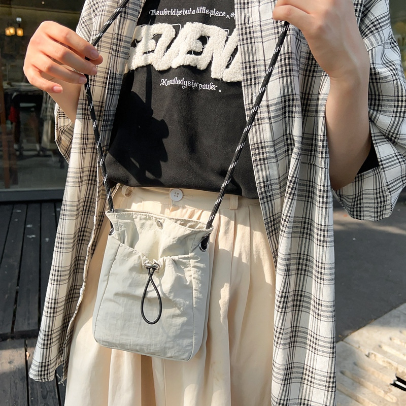 Japanese and Korean artistic single-shoulder crossbody bag, drawstring small bag, niche high-end sense, fashionable and lightweight, mini mobile phone nylon bag for women Application Scenario