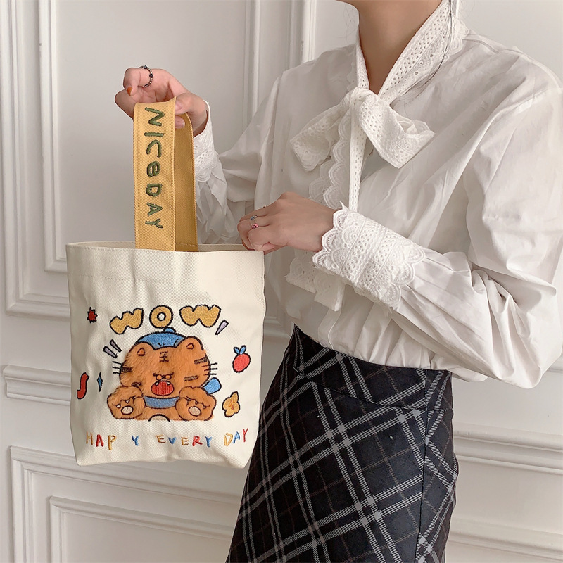 19241 Cute cartoon embroidered hand-held canvas bag, hand-held bucket bag, student commuting sundries bento bag wholesale Application Scenario