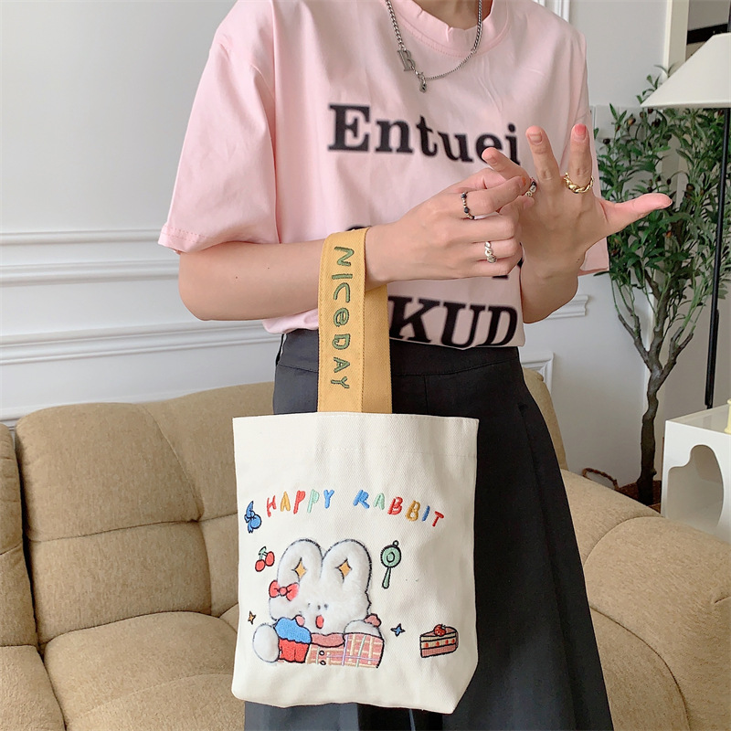 19241 Cute cartoon embroidered hand-held canvas bag, hand-held bucket bag, student commuting sundries bento bag wholesale details Picture