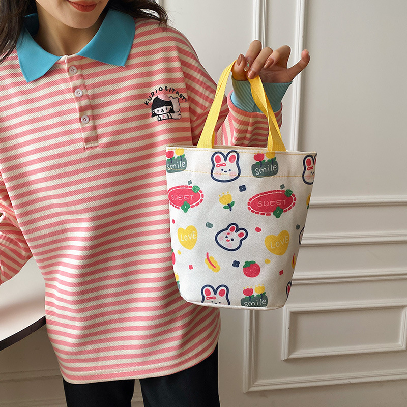 The 2023 new Japanese-style bucket-shaped hand-held canvas bag is simple, versatile and artistic. It features a small capacity bento box for both men and women details Picture