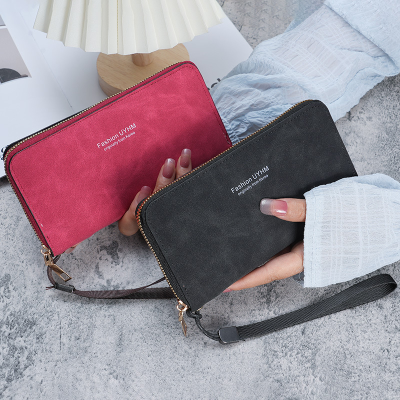 A lady is holding a long wallet. 2023 new Korean version handbag, multi-functional card case, mobile phone case, coin purse, and women's wallet Application Scenario