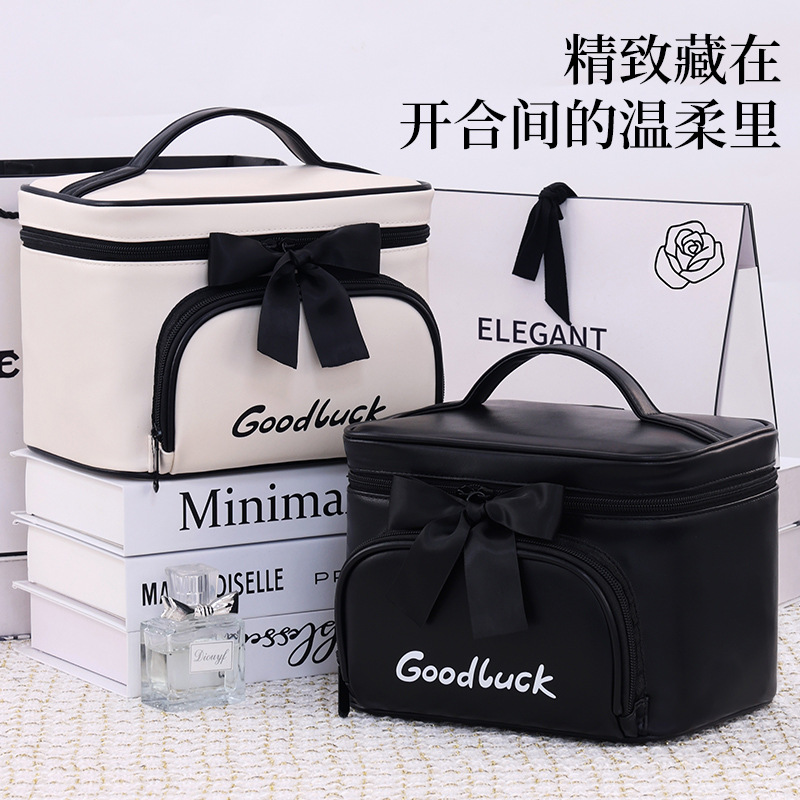 Xiaoxiangfeng bow makeup bag, large capacity, high-end feel, portable cosmetics storage bag for going out, hand-held makeup bag full figure