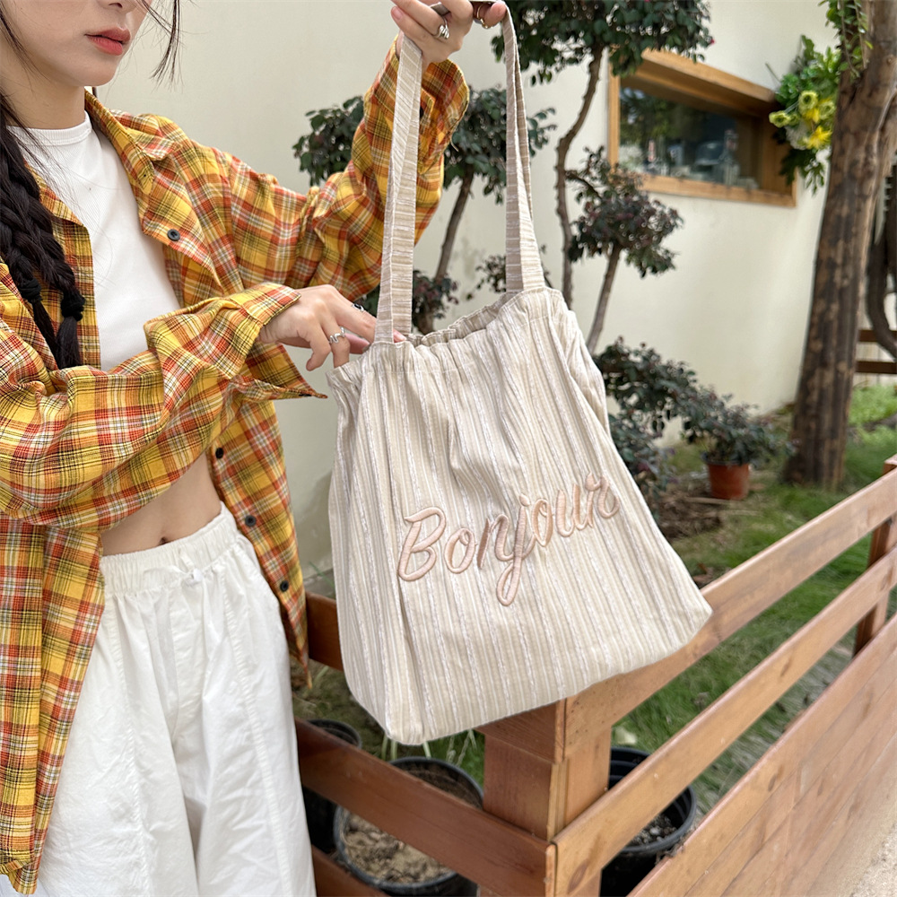 4922 Korean-style ins striped letter-embroidered single-shoulder tote bag, drawstring large-capacity canvas bag, commuter shopping bag Application Scenario