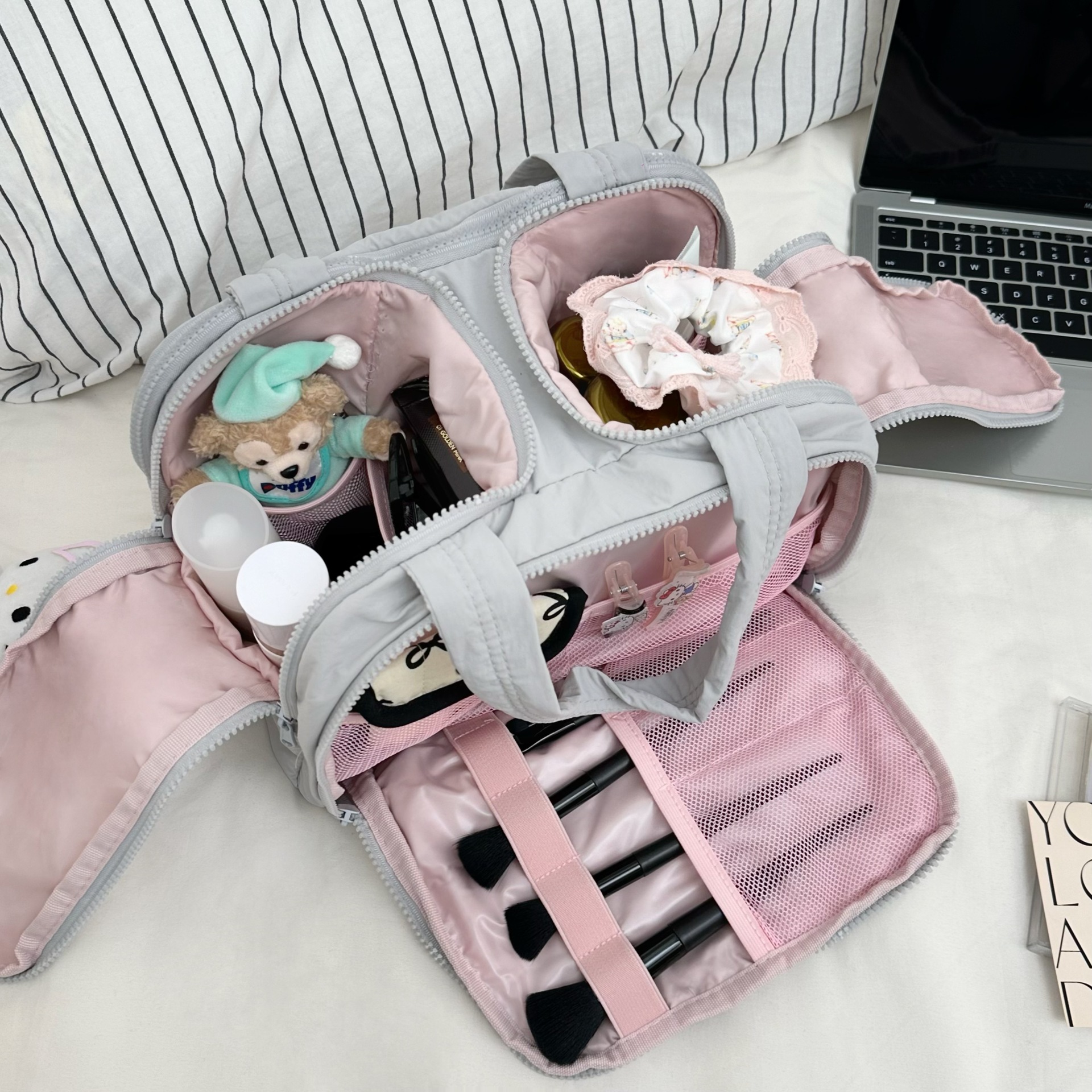 A new high-end large-capacity travel portable toiletry and storage bag for women in 2025, featuring simple grey and pink compartments full figure