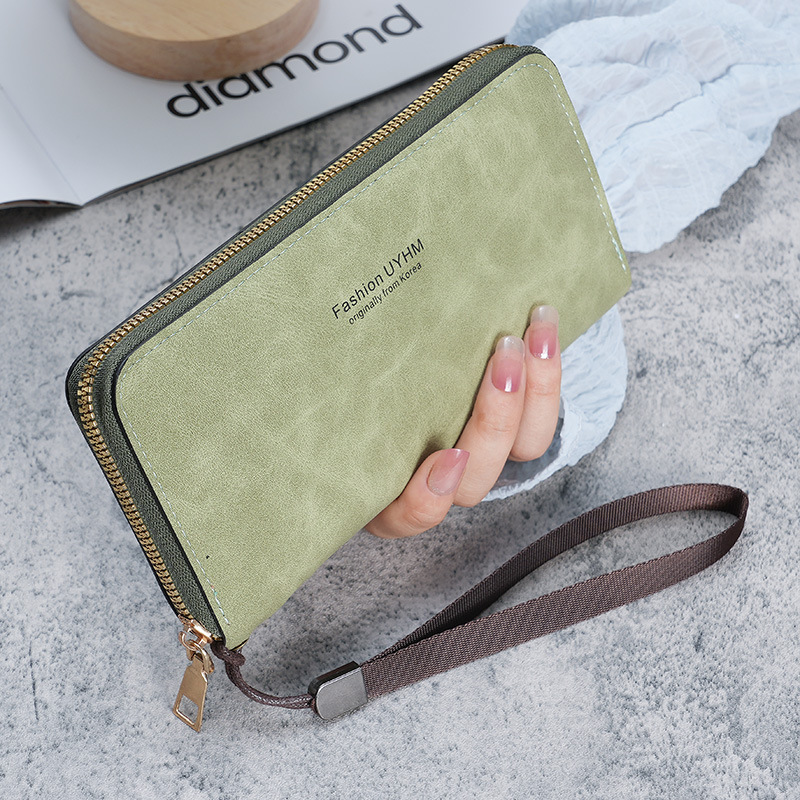 A lady is holding a long wallet. 2023 new Korean version handbag, multi-functional card case, mobile phone case, coin purse, and women's wallet full figure
