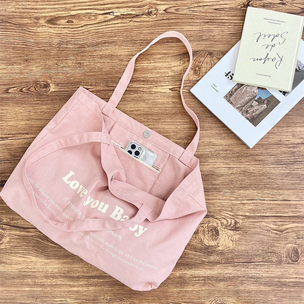 53142 Korean-style letter-printed canvas bag, a niche large-capacity commuter single-shoulder tote bag, suitable for carrying and shopping on one shoulder Application Scenario