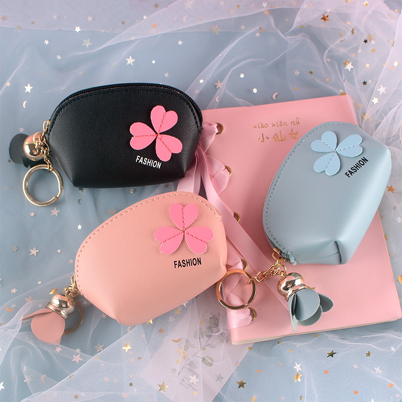 A Korean Instagram minimalist, mini and cute lady is holding a coin, multi-functional card case, pendant and coin purse full figure