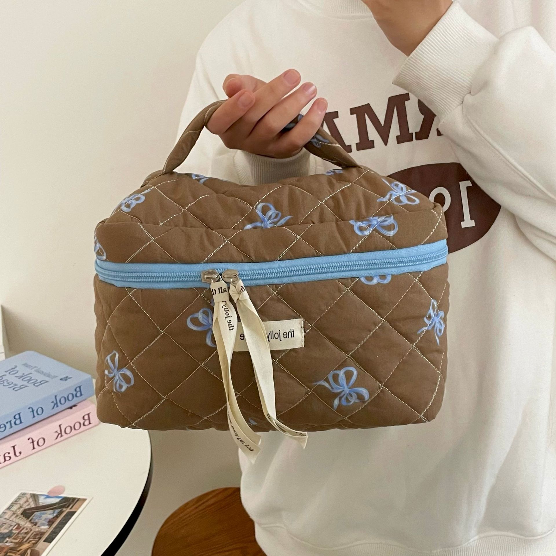 Color-blocking blue and coffee bow makeup bag, women's portable large-capacity hand-held toiletry bag, makeup and skin care product storage bag Application Scenario