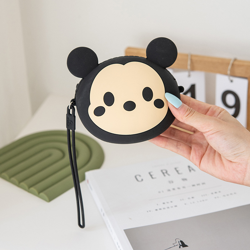 A cute and petite Korean girl's mini zipper wrist cartoon silicone coin purse is slung diagonally across a small bag for storing coins details Picture