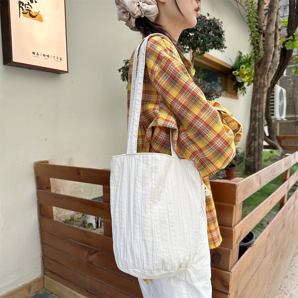 4942 Women's single-shoulder striped pleated solid color bucket bag, a niche, simple and portable hand-held shopping bag for women Application Scenario