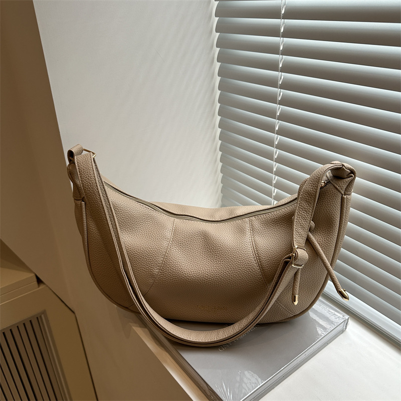 This crossbody bag is a solid-color one with a retro, fashionable and versatile design. It features a hand-held dumpling bag for women, a new Korean version single-shoulder bag full figure