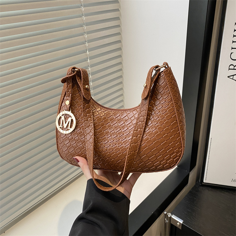 The 2025 new fashion women's bag is elegant, casual and versatile. It features a single-shoulder underarm bag in a solid color with a stylish texture and a hand-held crescent-shaped bag full figure