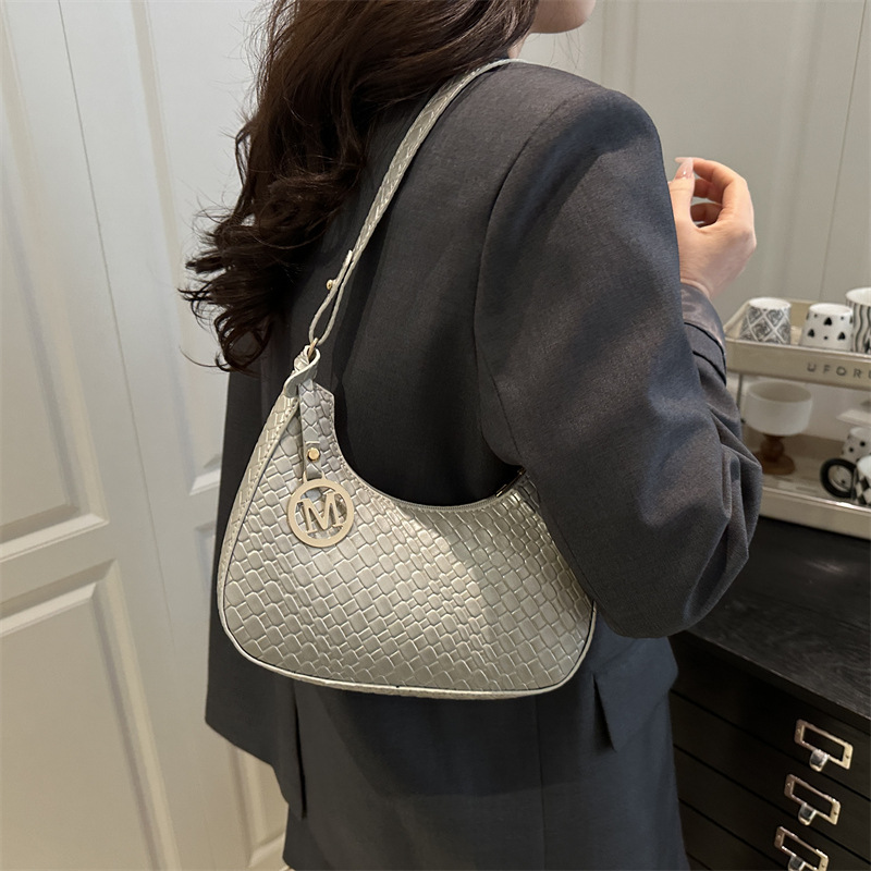 The 2025 new fashion women's bag is elegant, casual and versatile. It features a single-shoulder underarm bag in a solid color with a stylish texture and a hand-held crescent-shaped bag details Picture