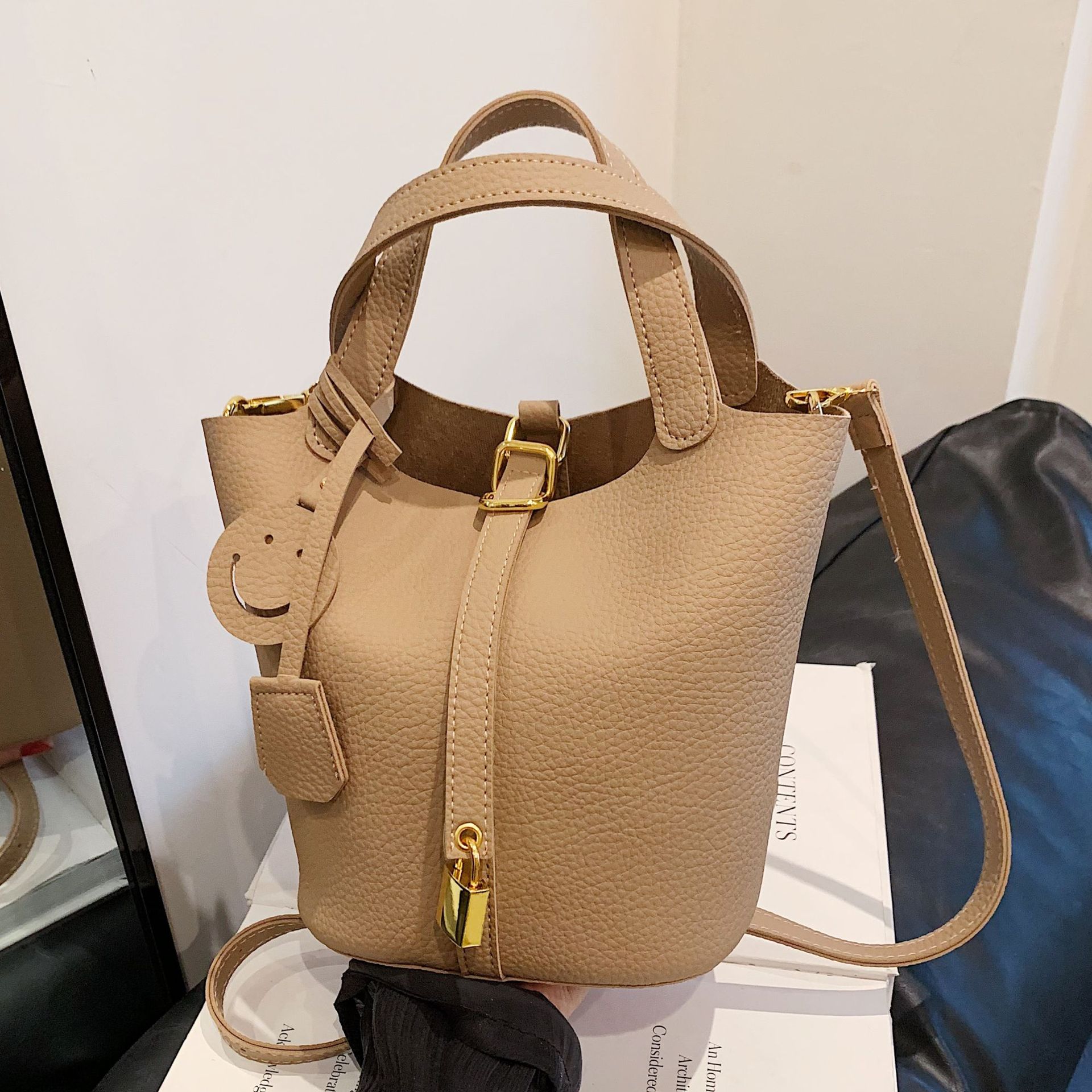 A new niche design women's handbag with lychee pattern in solid color, a simple and casual bucket bag for ladies, and a hand-held bag full figure