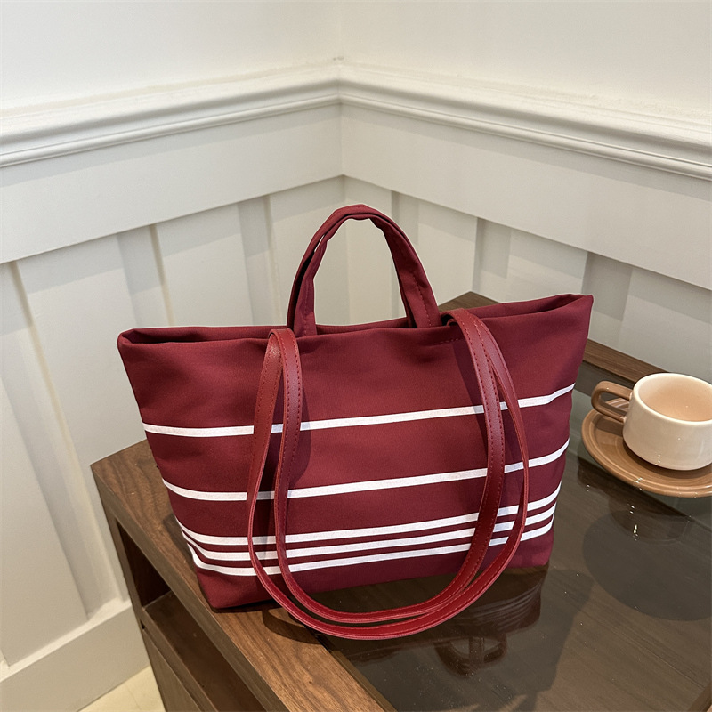 A new Korean canvas bag, striped hand-held shoulder tote bag, large-capacity women's bag, versatile commuting crossbody bag full figure