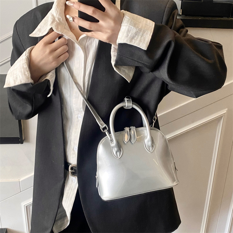 A new 2025 stylish, simple and versatile hand-held shell bag with a glossy finish and solid color for commuting. It's a casual single-shoulder crossbody bag Application Scenario