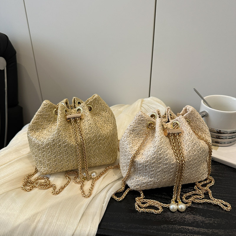A new summer commuting Korean-style simple solid color single-shoulder crossbody bag for women in 2025, featuring a straw-woven drawstring chain bucket Application Scenario